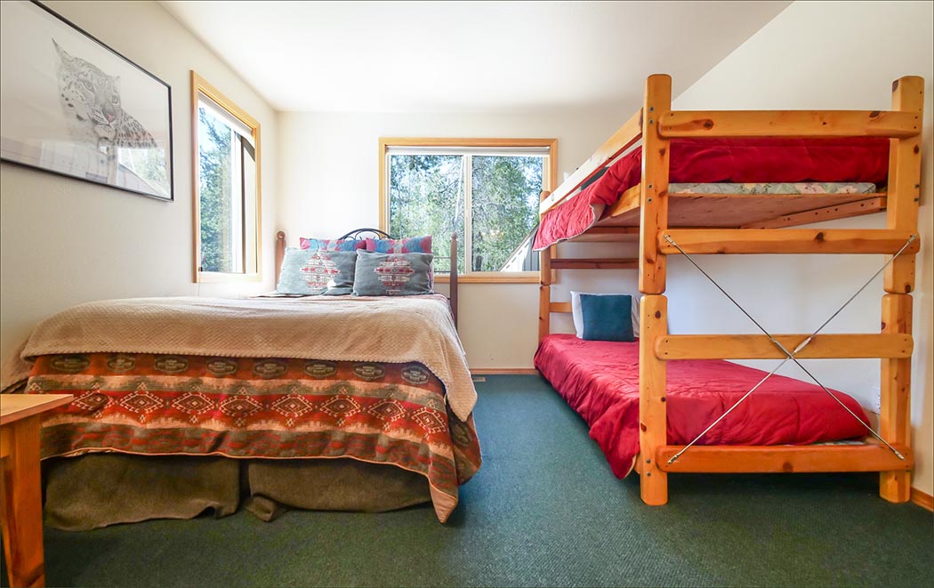 Sunriver vacation rental lower level features a bunk room with a queen bed and adjoining full bathroom.