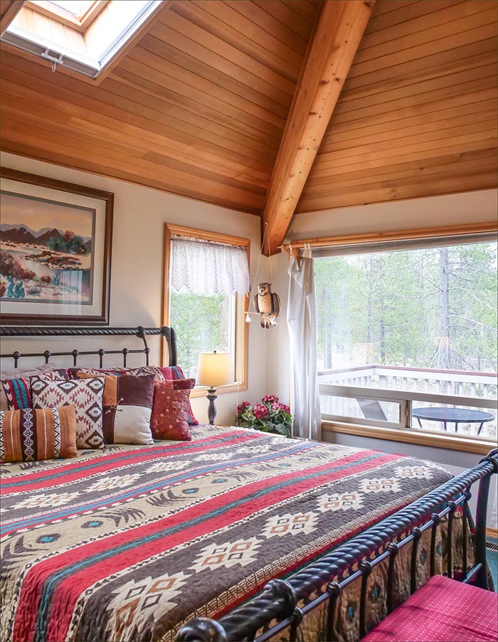 Master bedroom of this private Sunriver home includes a king sized bed and direct access to the upper level, rear facing deck.